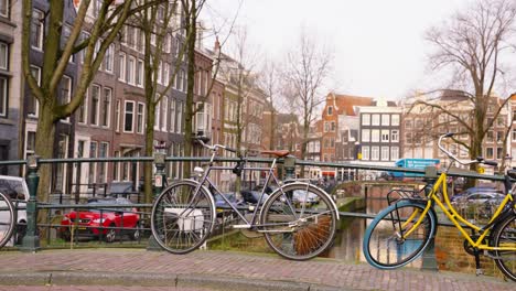 bicycles parked and locked on canal bridge in amsterdam, netherlands