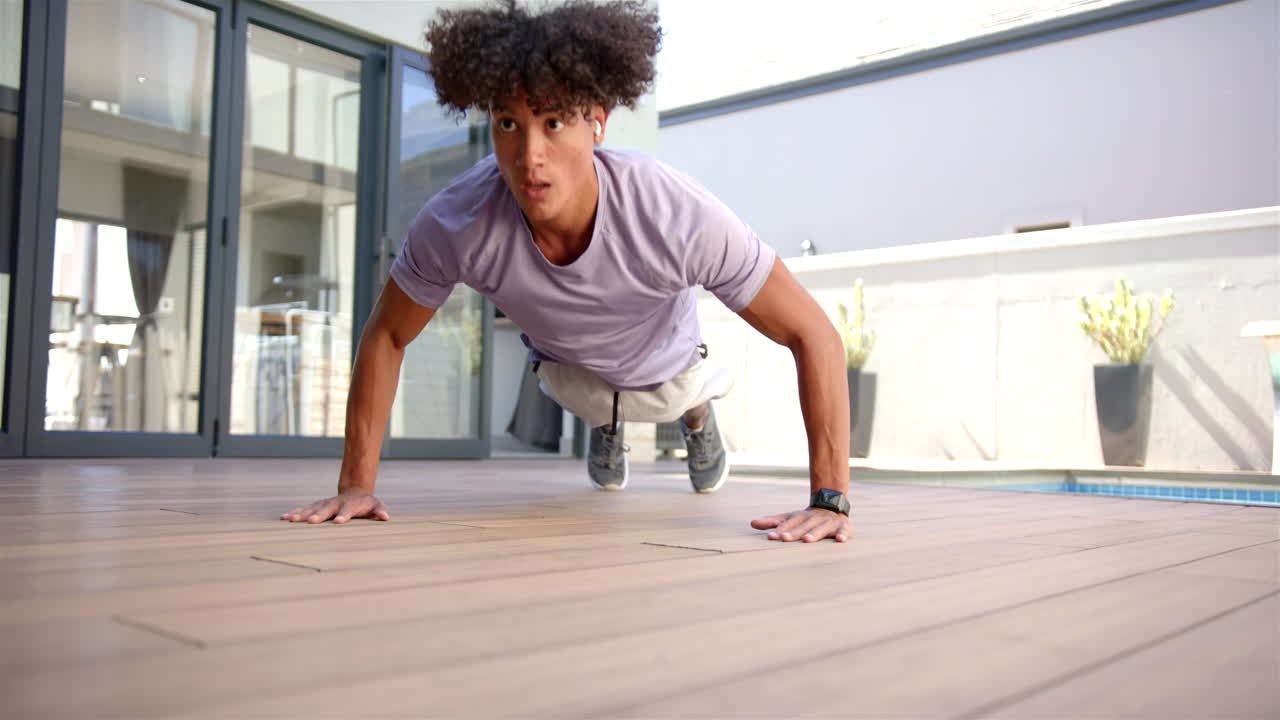Exercising on wooden deck at home, man doing push-ups