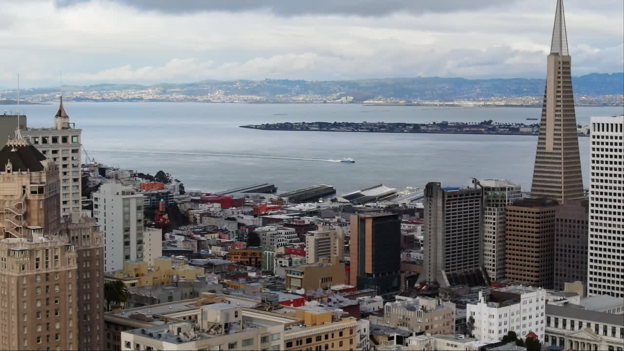 сан-франциско знаковая трансамериканская пирамида с островом сокровищ на заднем плане под облачным небом, штат калифорния, сша