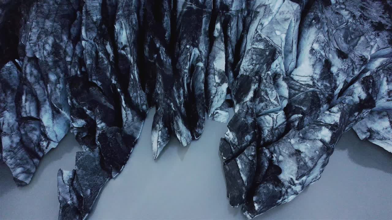 drone shot flying backwards with camera tilting up over Solheimajokull Glacier, Iceland 4k