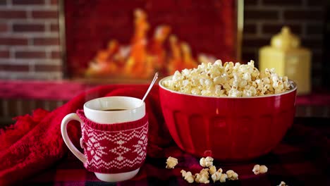 Animation-of-a-cup-of-tea-with-popcorns-and-a-fireplace,-christmas-concept-animation-with-no-people