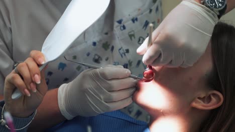professional dentist examines teeth of female patient in clinic