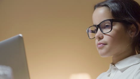 low-angle shot of smart schoolgirl doing homework