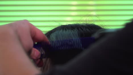 close up of girl getting her hair ironed and combed at hair dresser