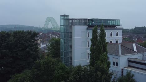 Aerial-view-Widnes-Catalyst-science-discovery-centre-museum-modern-building-Runcorn-bridge-skyline-dolly-right