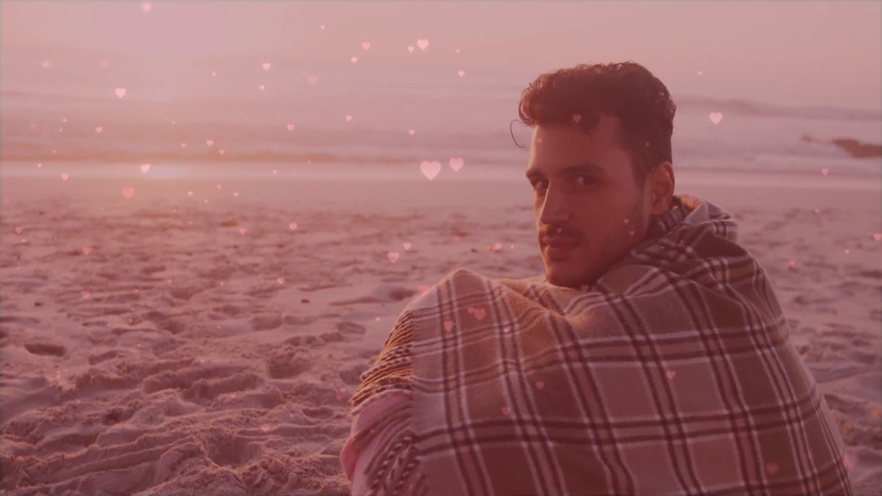Homem sentindo alguém atrás durante o pôr do sol na praia, virando-se para a câmera e sorrindo, com corações para marketing.