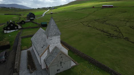 viðareiði church, faroe islands: aerial view in orbit over the church and cemetery of this faroese village