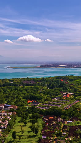 cloud shadows drift over lush tropical resort near ocean coast in sri lanka landscape, vertical aerial establishing