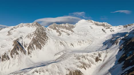 Drohnen-Zeitraffer-Von-Wolken,-Die-Im-Winter-über-Eine-Bergkette-Fließen