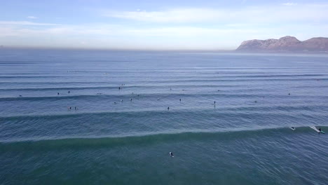 imágenes aéreas de surfistas en el mar en sudáfrica, muizenberg