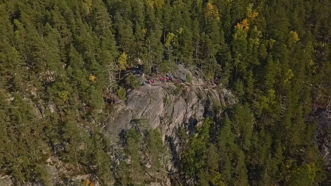 montaña en un bosque, parque nacional de finlandia, gente y turistas en la cima