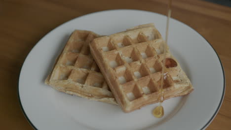 close up slow motion of syrup being poured onto waffles