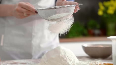 Woman-sifting-flour-in-kitchen