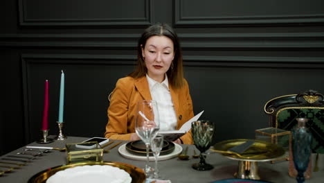 Asian-woman-sitting-at-elegant-table