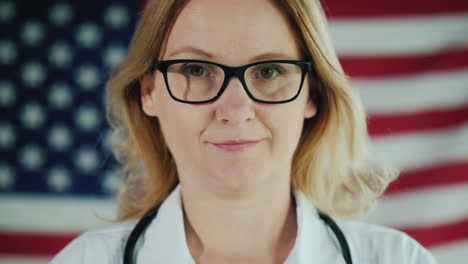 The-Face-Of-A-Doctor-In-A-Mask-Against-The-Background-Of-The-Us-Flag