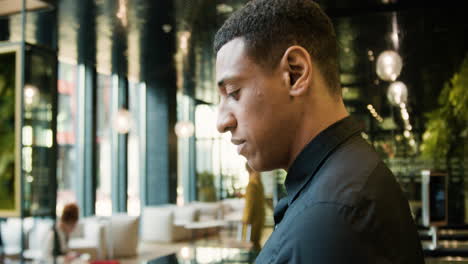 Side-view-of-african-american-receptionist-in-a-hotel