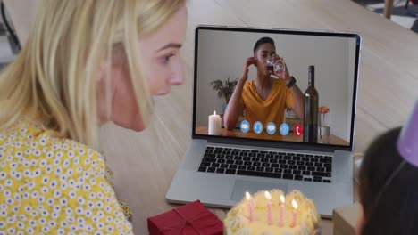 caucasian mother and daughter celebrating birthday on video call on laptop at home