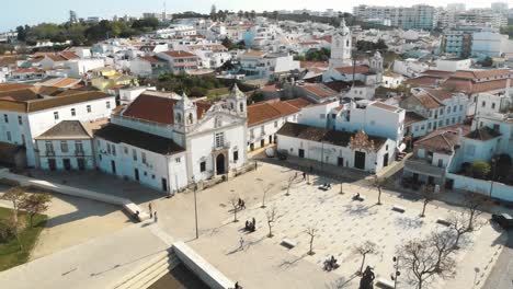 Iglesia-De-Santa-Maria-De-Lagos-En-La-Plaza-Del-Casco-Antiguo,-En-Algarve,-Portugal---Toma-Panorámica-Aérea-Ascendente