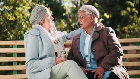 two elderly women friends having a conversation on a park bench