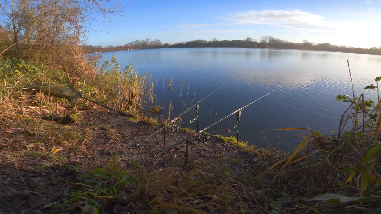 Serene lakeside fishing with rods on a sunny day, nature's tranquility