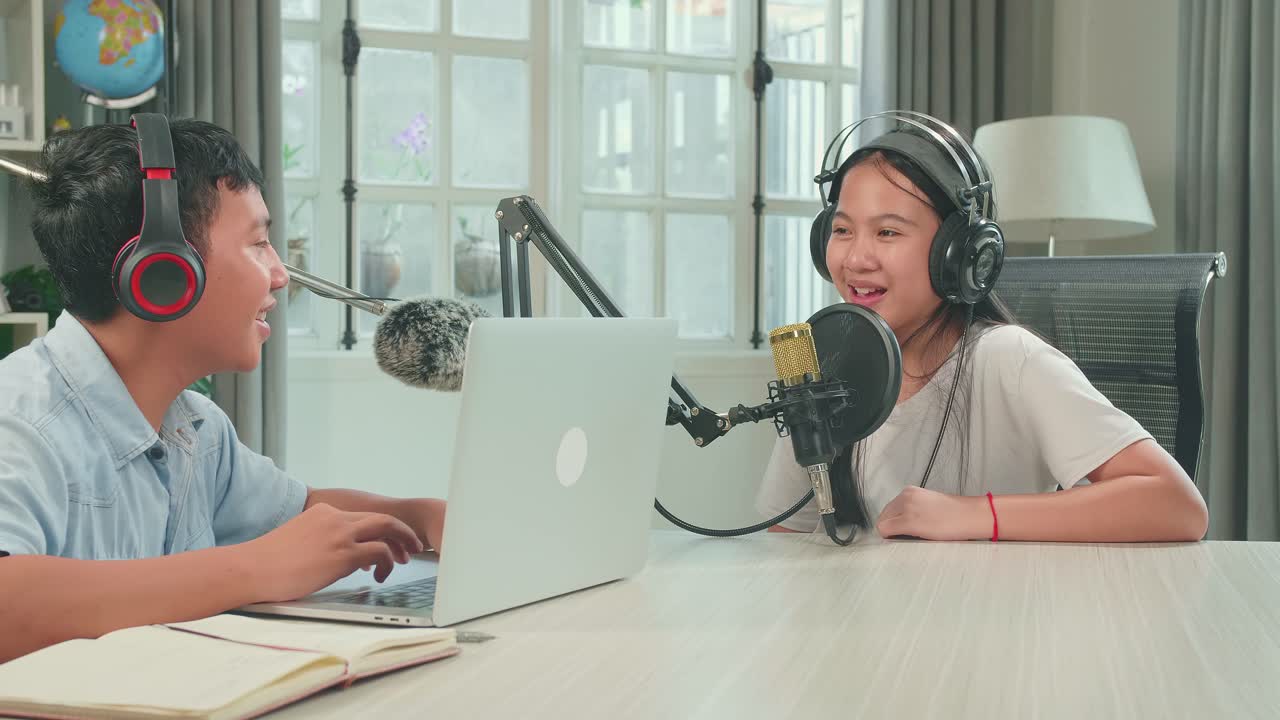 Asian Boy Host Record Podcast Use Microphone Wear Headphone And Reading Comment On Laptop Interview Guest Conversation For Content In His Home Studio. Content Creator Concept