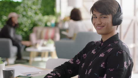 portrait-handsome-young-caucasian-man-student-smiling-happy-entrepreneur-enjoying-successful-career-listening-to-music-wearing-headphones-in-trendy-startup-office