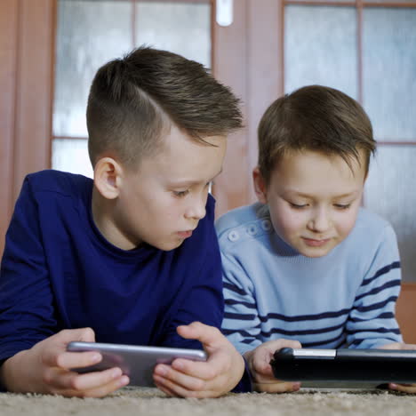 cute little brothers playing games at smartphone. children use gadgets