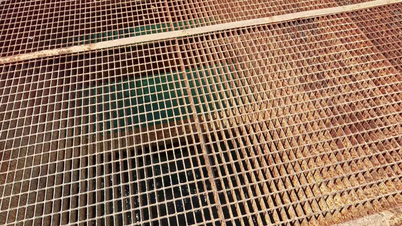 A metal grate with water visible below