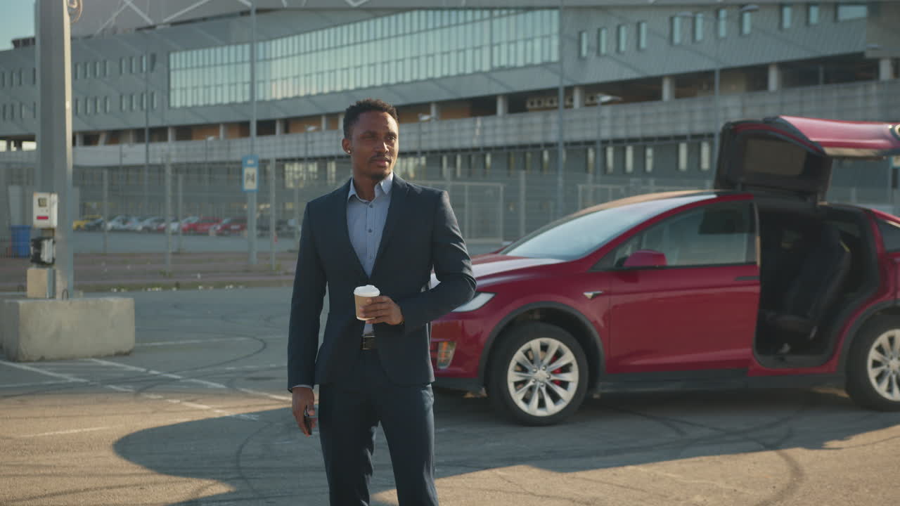 hombre de negocios con café en el estacionamiento cerca del estadio