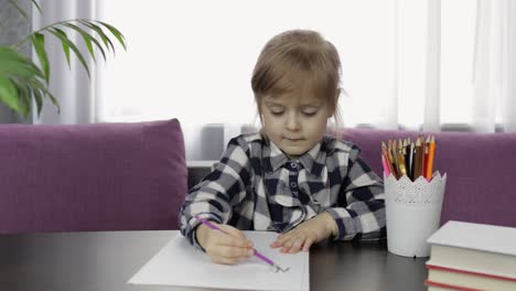 cute child girl studying drawing picture with pencil at home. distance education