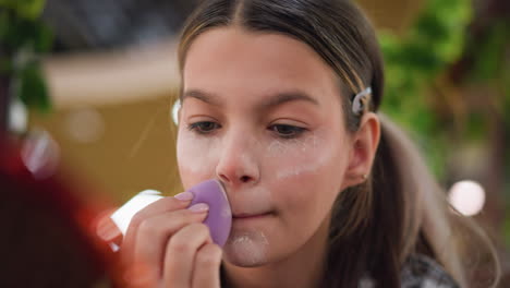 close-up view of young woman applying translucent powder on jawline using purple makeup sponge for flawless makeup application, focusing on smoothing powder for perfect finish