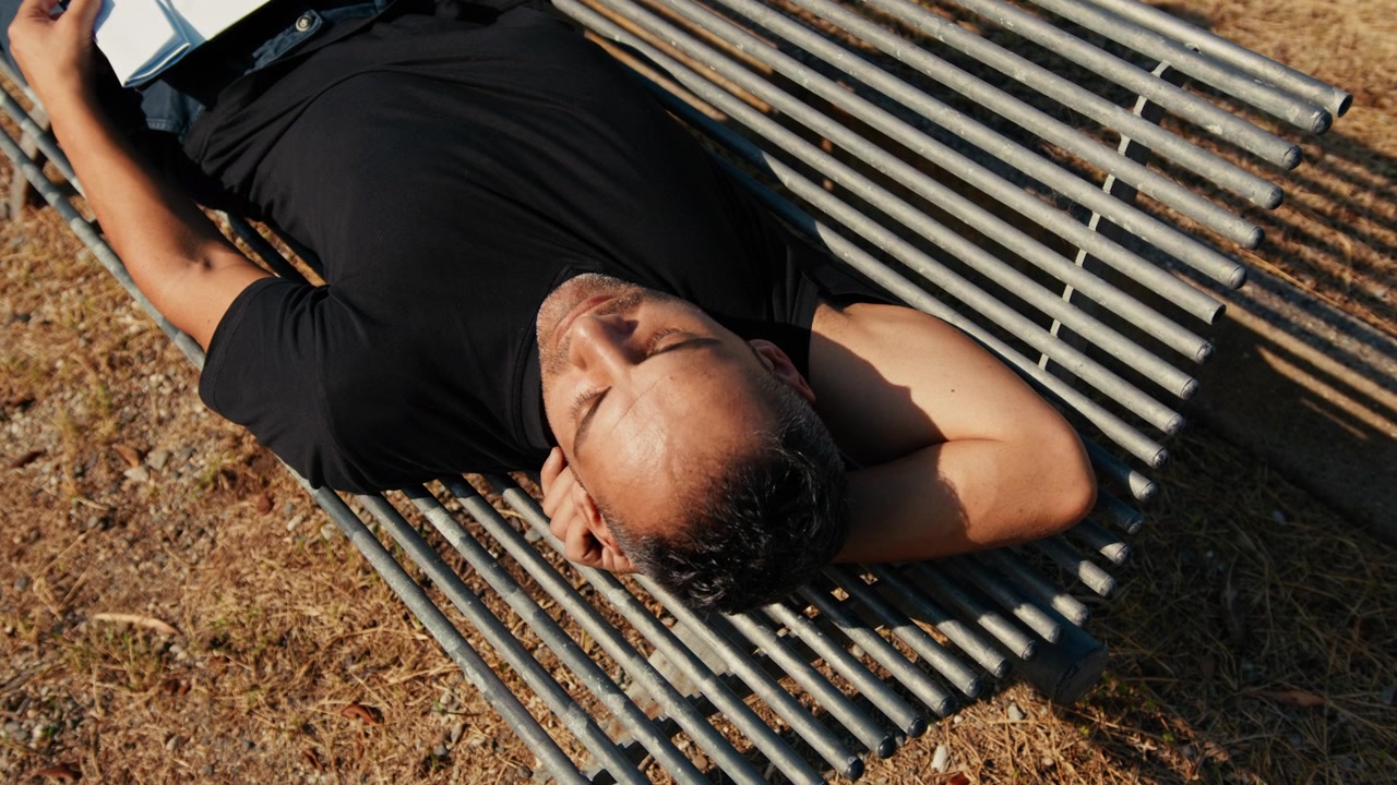 homme dormant sur un banc de parc