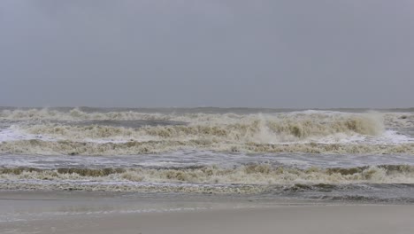 violent ocean waves during a tropical storm crash towards a beach