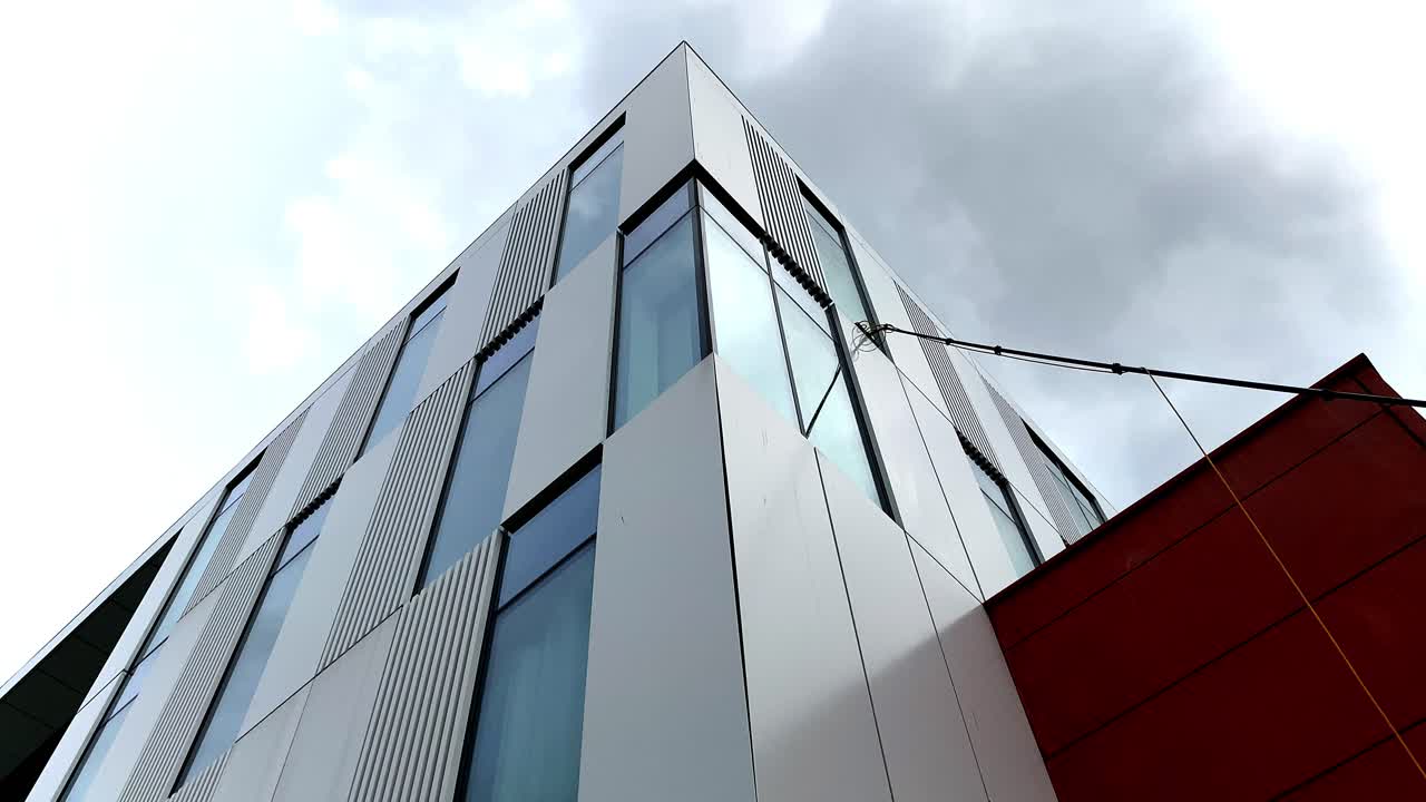 Low angle view commercial window cleaning using modern reach and wash techniques. Water fed pole