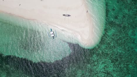 top down perspective pan across patawan island, banca boats beached and coastline