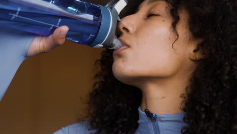 mujer joven bebiendo agua