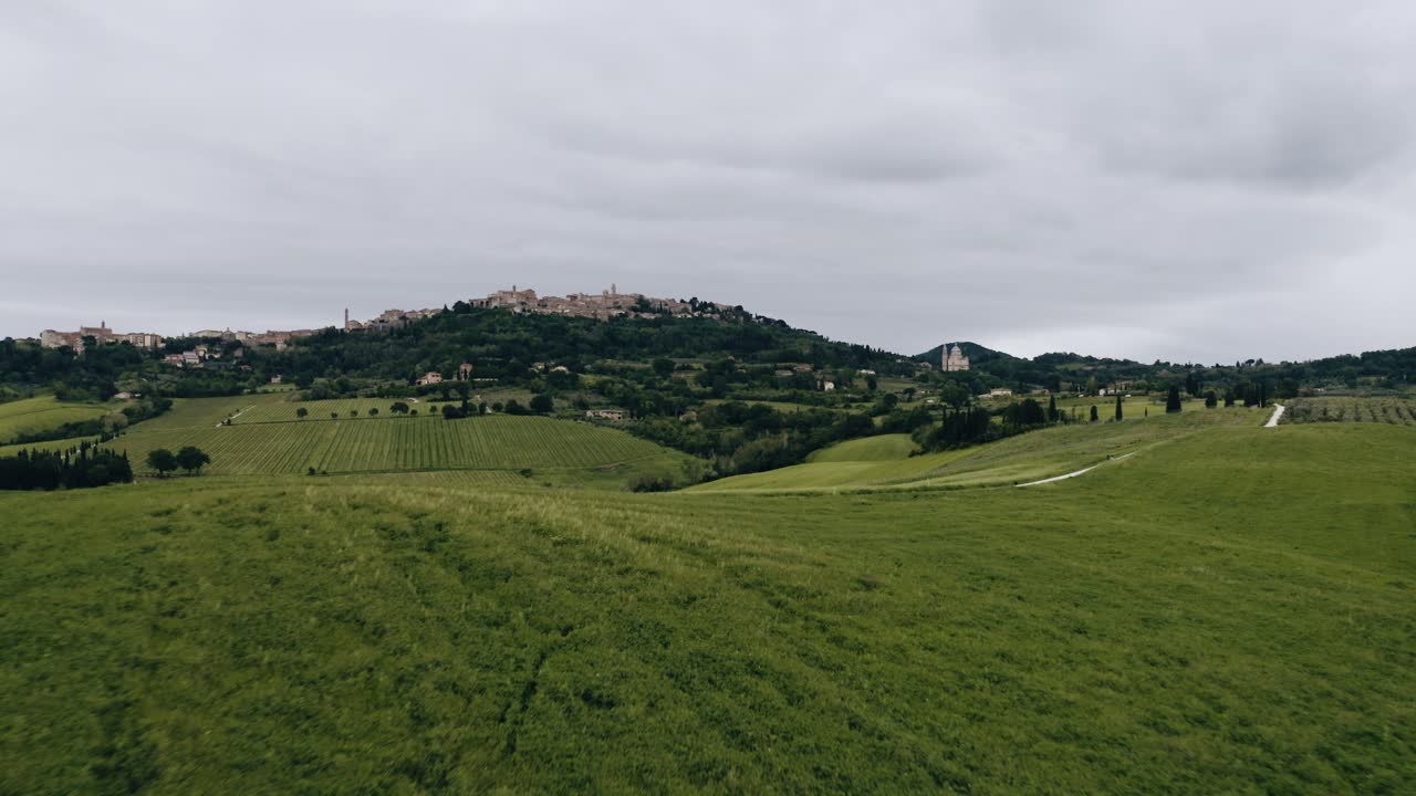 Drone shot flying low over fields of crops in Italy's countryside