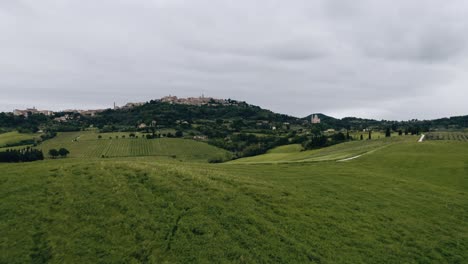 drone shot flying low over fields of crops in italy's countryside