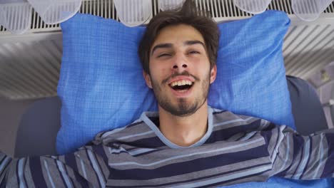 joven despertando y bostezando sonriendo. buen día.