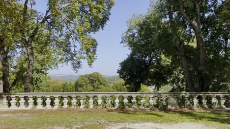 castle garden with stone wall and beautiful large trees in good weather