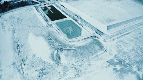 Aerial-Flyover-of-Frozen-Water-Reservoir-Covered-with-Ice-and-Snow-4K