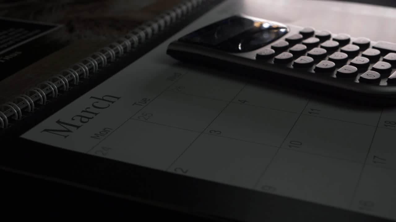 Calculator on March calendar close up panning shot