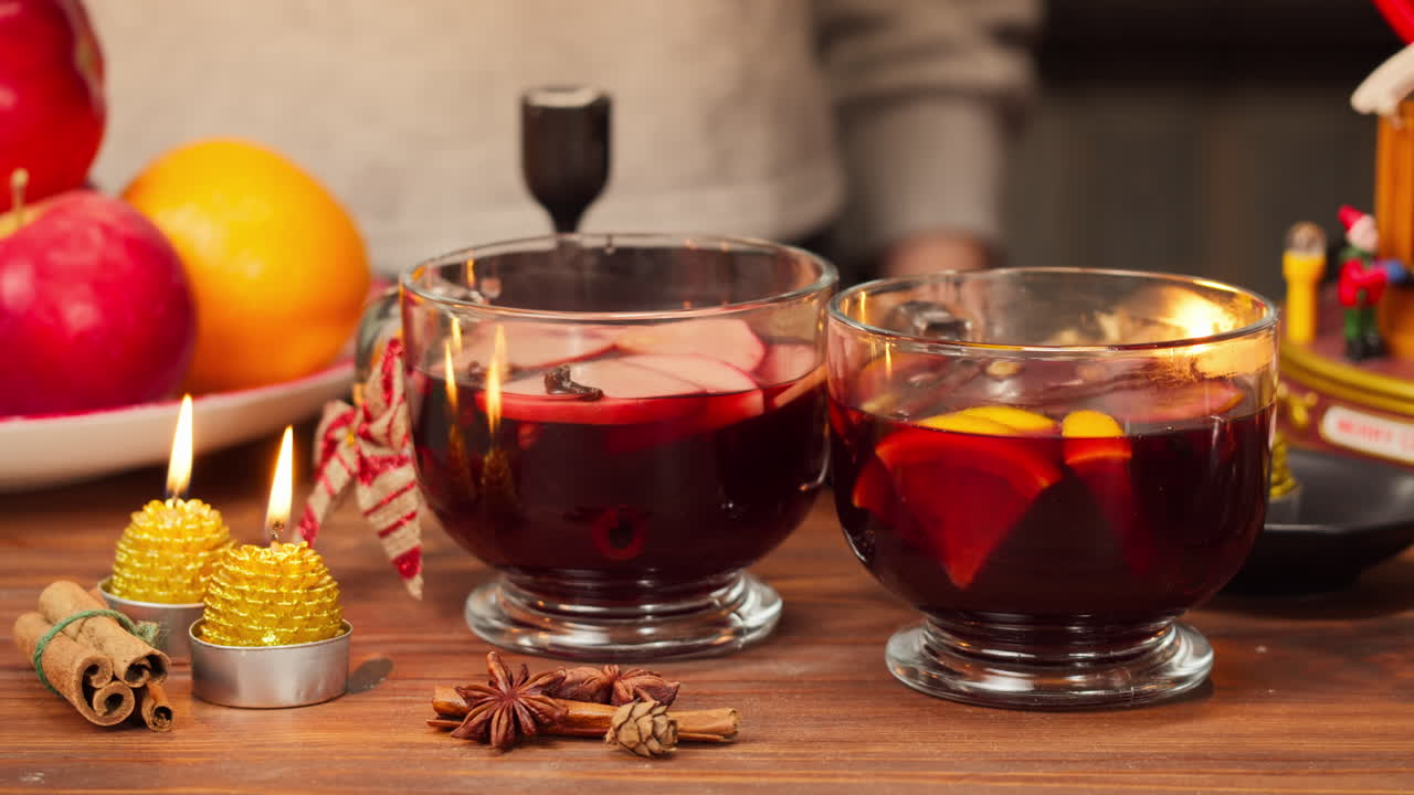 Hände servieren warmen Glühwein auf einem festlichen Holztisch
