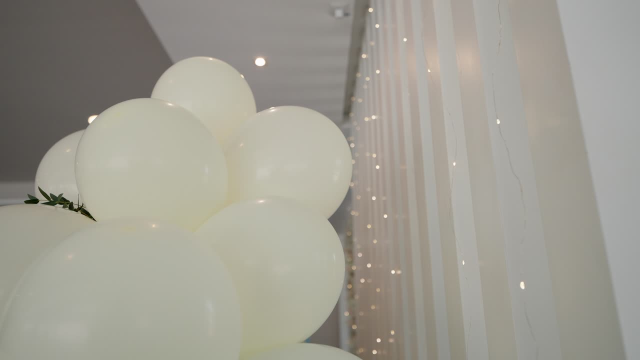 cluster of white balloons beside warm lights in elegant event space