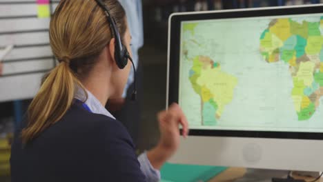 mujer joven trabajando en una computadora en un almacén 4k