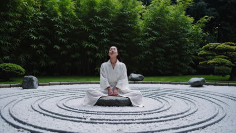 woman meditating in a zen garden