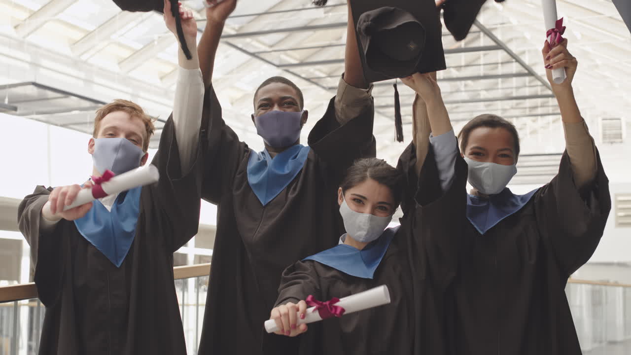 Group of Four Happy Graduates with Diplomas