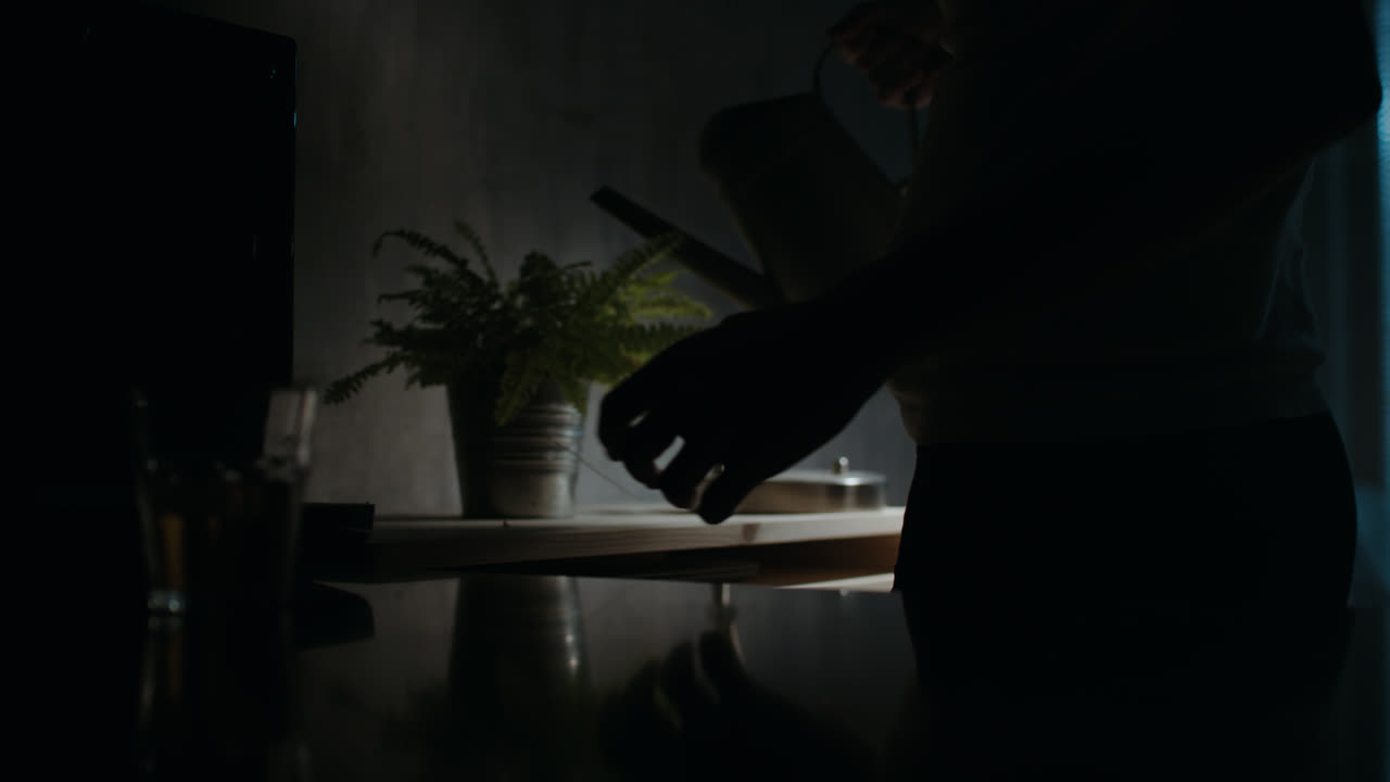 A sad man reads a book at night in his underwear