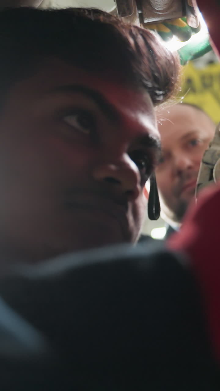 자동차 수리 작업에 종사하는 엔지니어, 실험실 기술자가 태블릿을 가지고 접근하여 관찰하고 메모를 취하는 동안, 도구와 함께 기계 작업실 설정, 승강된 차량, 진행 중인 기술 검사