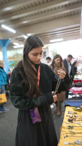 woman looking at jewelry at a market